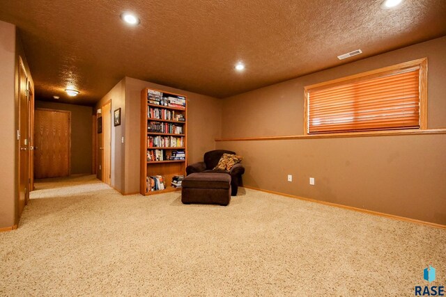 sitting room featuring visible vents, baseboards, carpet flooring, recessed lighting, and a textured ceiling