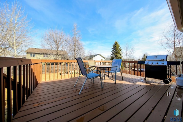 deck with outdoor dining space and grilling area