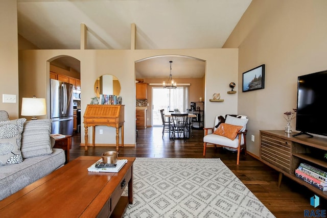 living area featuring arched walkways, lofted ceiling, and dark wood-style flooring