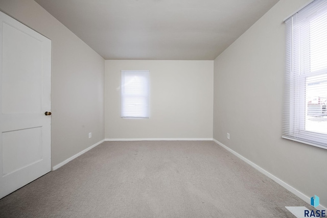 empty room featuring baseboards and carpet