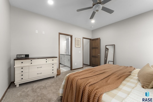 bedroom with ensuite bathroom, recessed lighting, baseboards, light colored carpet, and ceiling fan