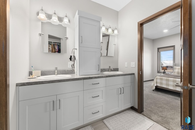 full bathroom featuring a sink, connected bathroom, and double vanity