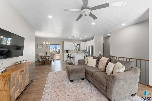 living area with recessed lighting and light wood-style floors