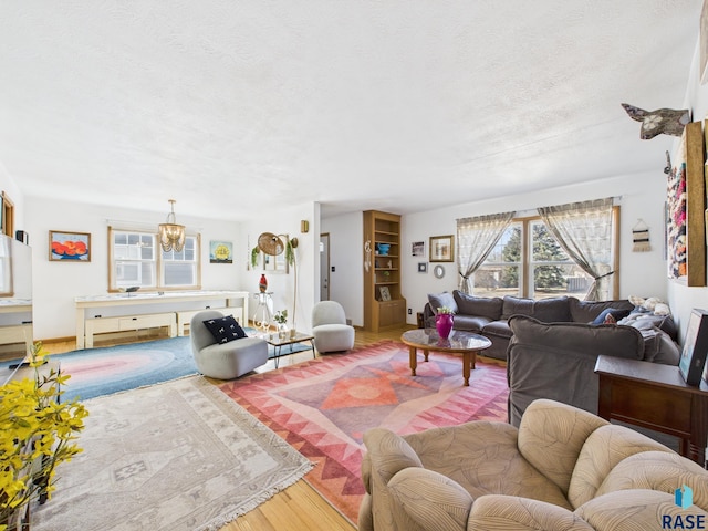 living area featuring a notable chandelier, a textured ceiling, and wood finished floors