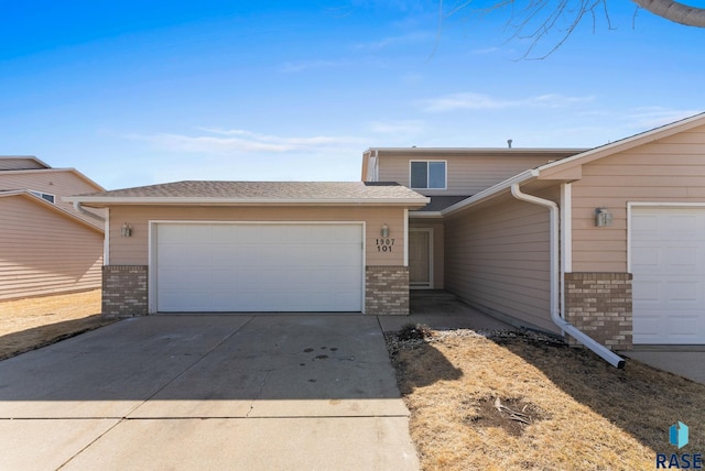 view of front of home with an attached garage, brick siding, and driveway