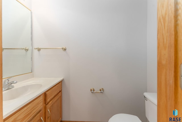 half bathroom with vanity and toilet