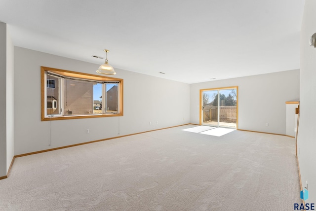 carpeted spare room with visible vents and baseboards