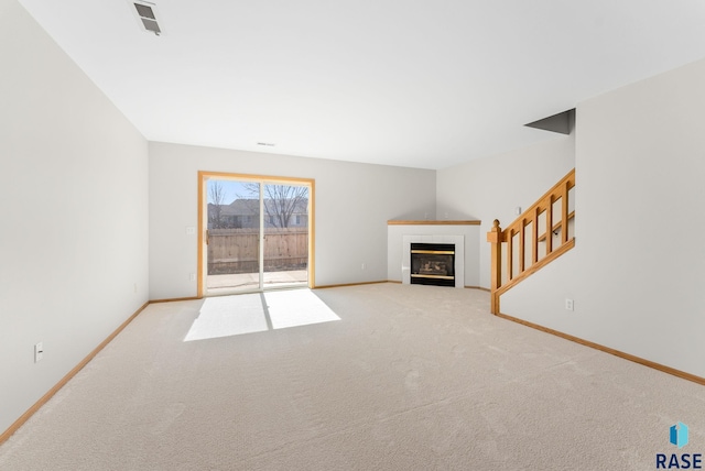 unfurnished living room with baseboards, carpet, and a fireplace