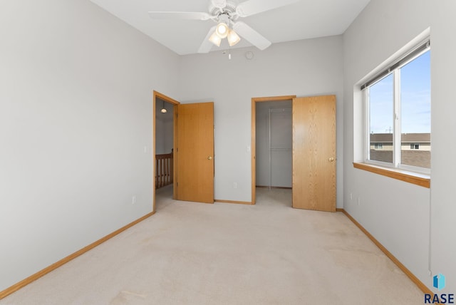 carpeted bedroom with a spacious closet, baseboards, a closet, and ceiling fan