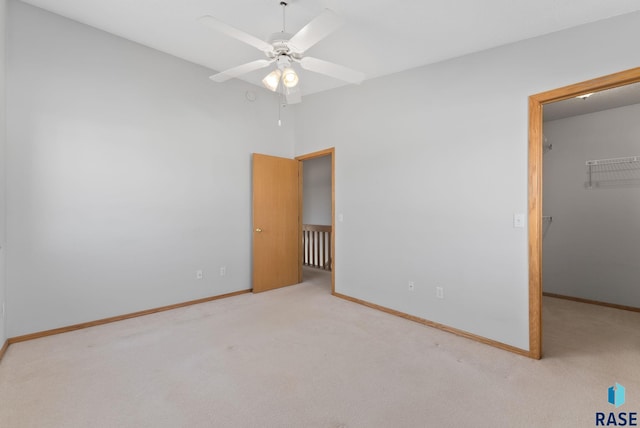 unfurnished bedroom with a closet, a walk in closet, baseboards, and carpet floors