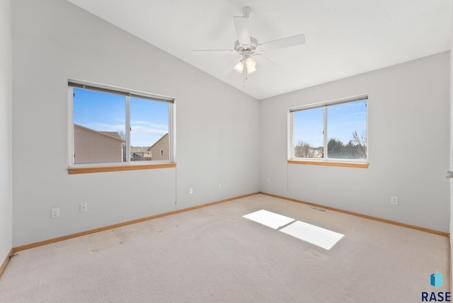 empty room with visible vents, ceiling fan, baseboards, lofted ceiling, and carpet floors