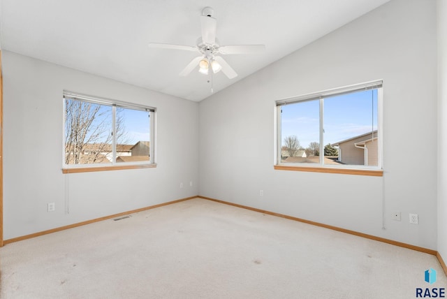 unfurnished room featuring a wealth of natural light, visible vents, lofted ceiling, and carpet flooring