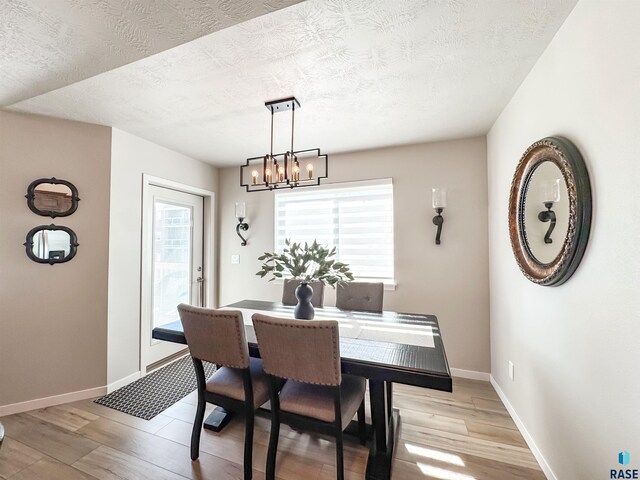 dining room with a wealth of natural light, light wood-style flooring, and baseboards