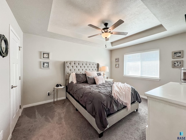 bedroom featuring baseboards, ceiling fan, a textured ceiling, a raised ceiling, and carpet flooring