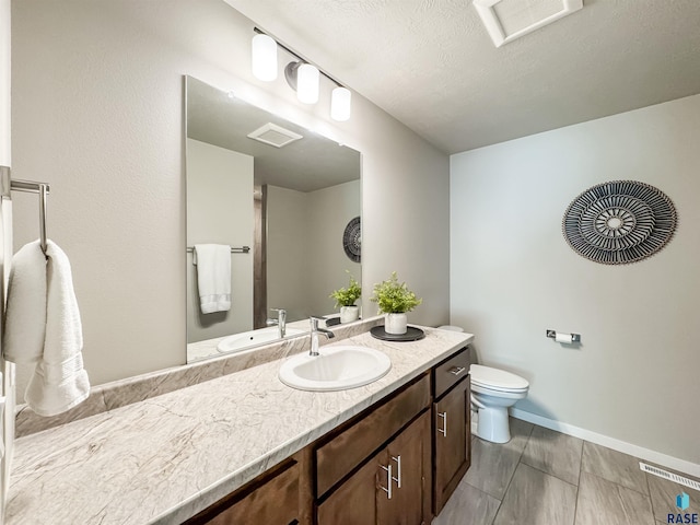 bathroom featuring visible vents, baseboards, toilet, and vanity