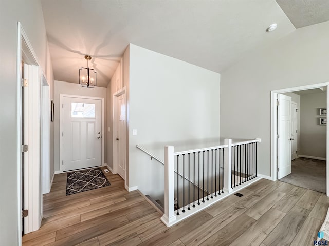 entrance foyer featuring lofted ceiling, baseboards, and wood finished floors