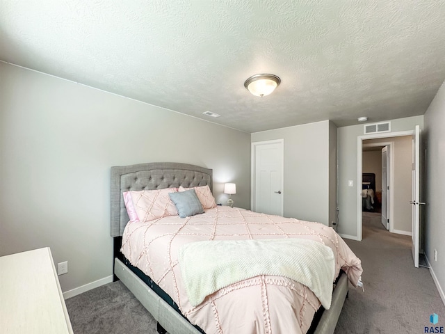 bedroom featuring visible vents, carpet floors, a textured ceiling, and baseboards