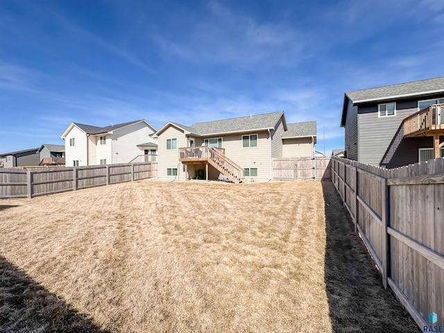 view of yard featuring a residential view, stairway, and a fenced backyard