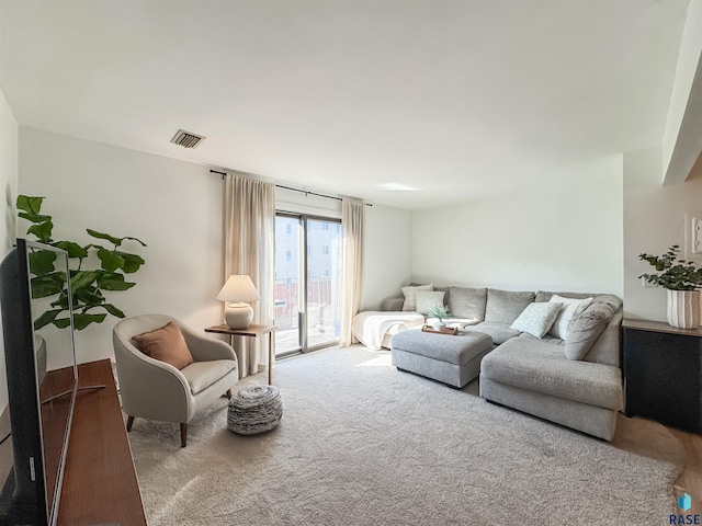 living area featuring visible vents and carpet floors