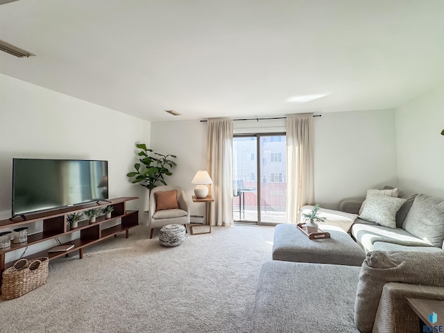 living area with visible vents, a baseboard heating unit, and carpet floors