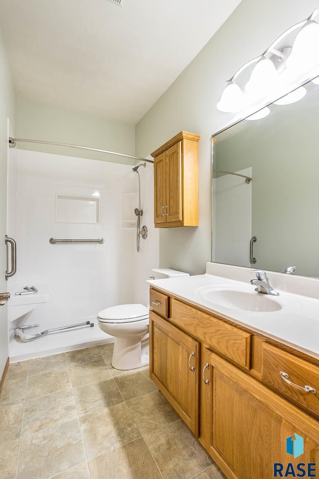 bathroom with a shower, toilet, and vanity