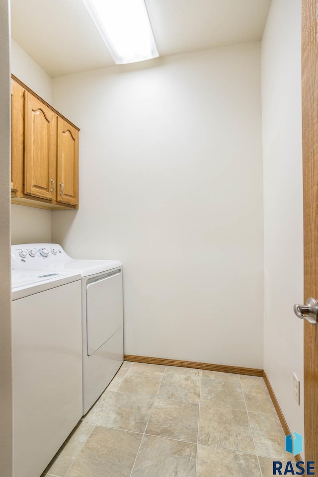 clothes washing area featuring cabinet space, baseboards, and washer and clothes dryer