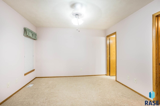 carpeted spare room with visible vents and baseboards