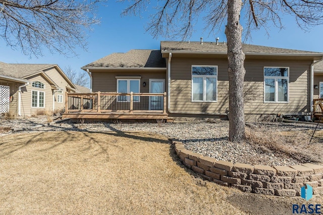 rear view of property featuring a lawn and a wooden deck