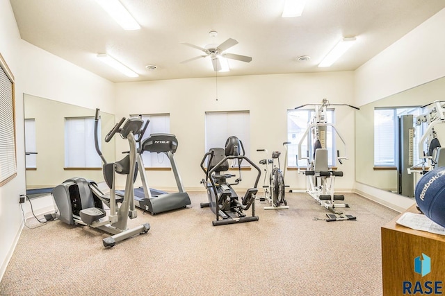 workout area featuring a ceiling fan and baseboards