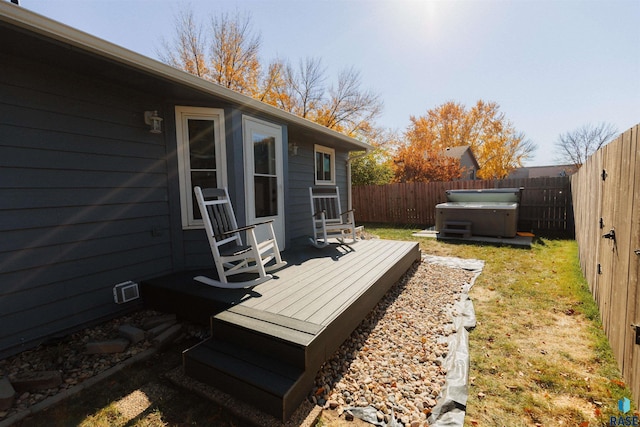 wooden deck featuring a fenced backyard and a hot tub