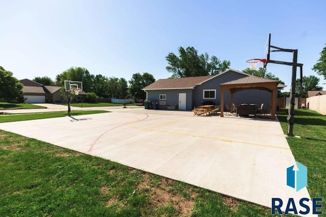 view of basketball court featuring a gazebo, fence, a yard, and basketball court