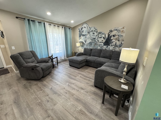 living room with recessed lighting, baseboards, and wood finished floors