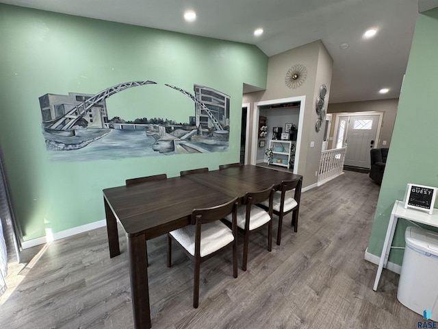 dining area featuring recessed lighting, wood finished floors, baseboards, and vaulted ceiling