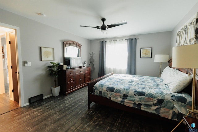 bedroom with dark wood-style floors, visible vents, ceiling fan, and baseboards