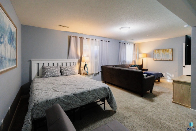 bedroom featuring light carpet, visible vents, and a textured ceiling