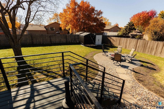 exterior space with an outbuilding, a storage unit, a fenced backyard, and a fire pit