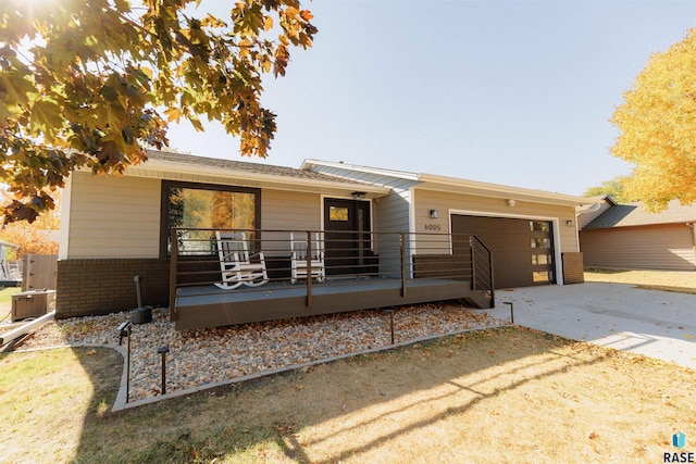 single story home with driveway, brick siding, and an attached garage