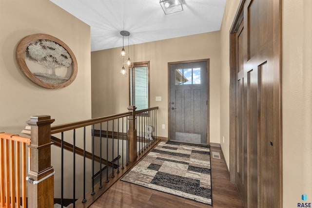 foyer entrance with baseboards and wood finished floors