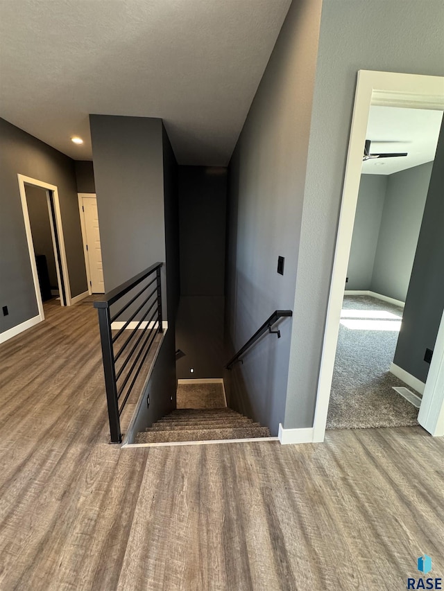 staircase featuring baseboards and wood finished floors