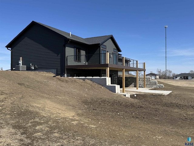 view of side of home with a wooden deck and central AC