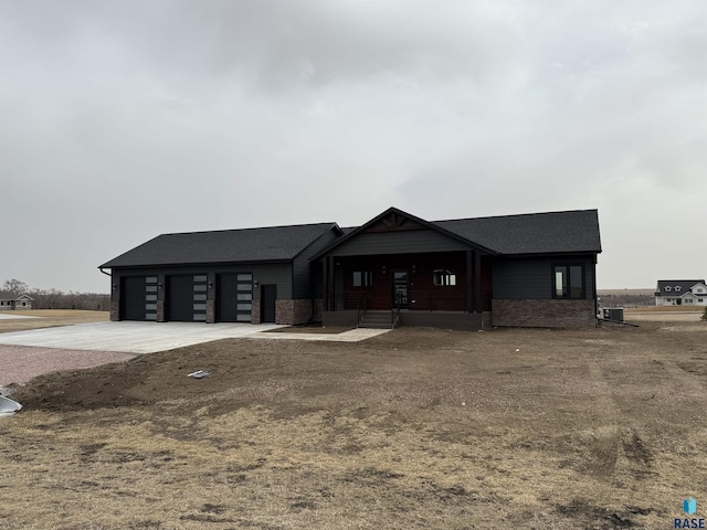 view of front facade with concrete driveway, brick siding, a garage, and a shingled roof