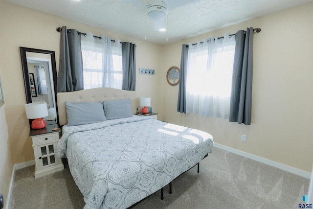 carpeted bedroom with multiple windows and baseboards