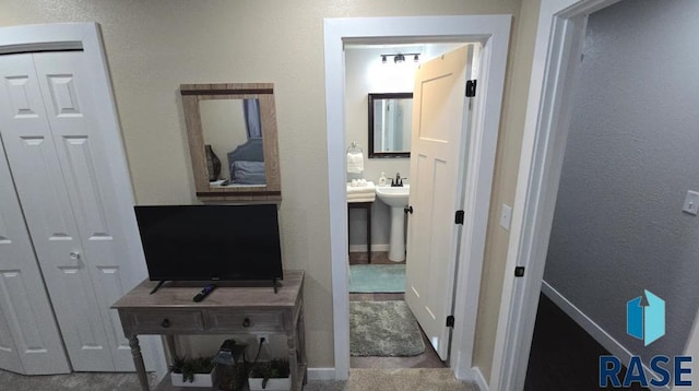 hallway with baseboards and a textured wall