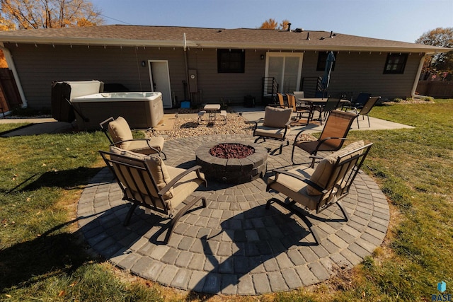 rear view of property with a patio, a yard, a fire pit, and a hot tub