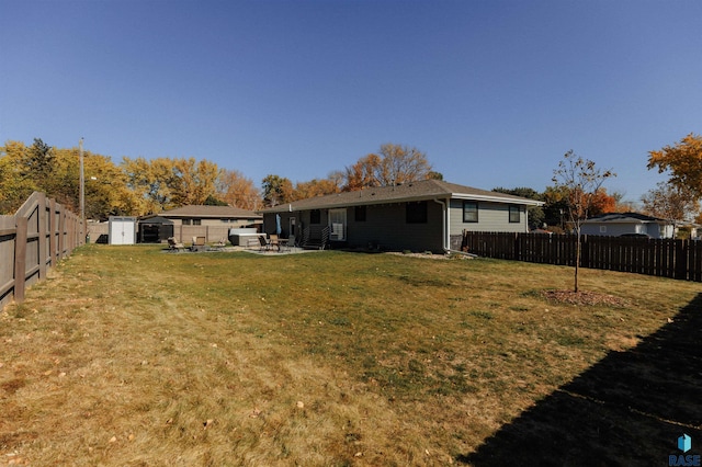 view of yard with an outbuilding, a storage unit, a fenced backyard, and a patio