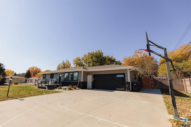 view of front of property featuring fence, concrete driveway, a front yard, a garage, and a gate