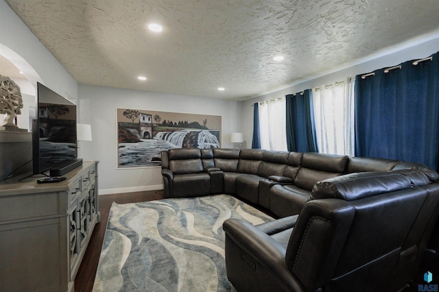 living room featuring recessed lighting, baseboards, a textured ceiling, and dark wood finished floors