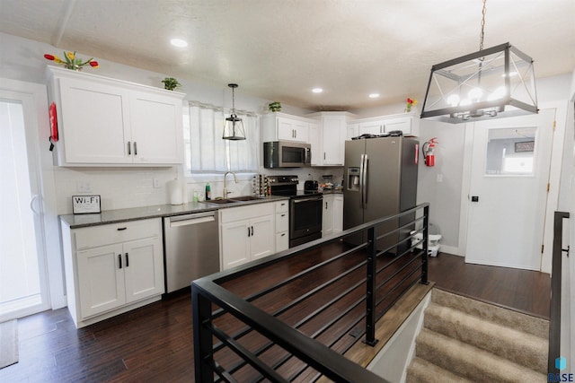 kitchen featuring a sink, dark wood-type flooring, decorative backsplash, and stainless steel appliances