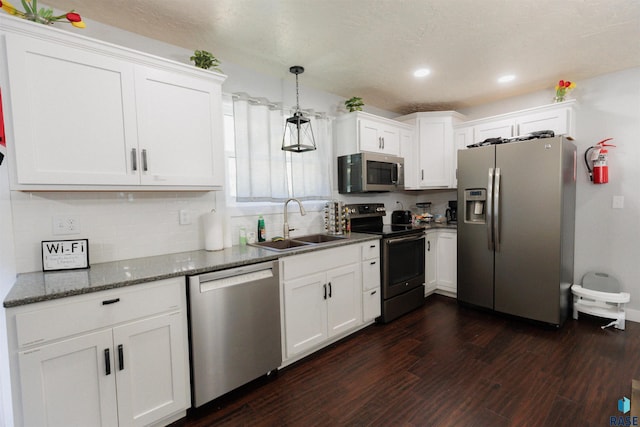 kitchen with a sink, appliances with stainless steel finishes, white cabinets, and dark wood-style flooring