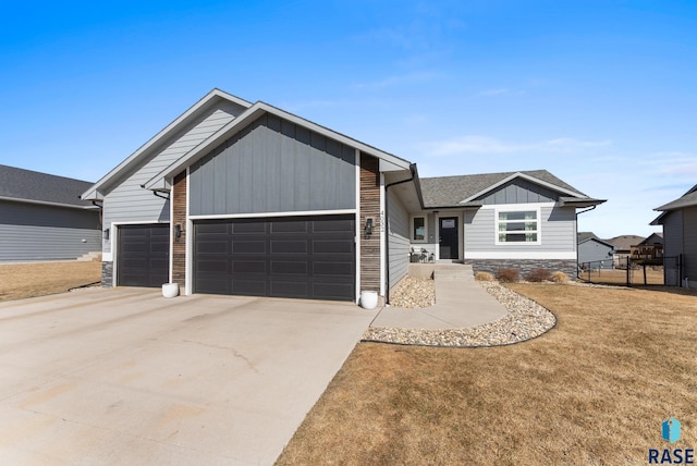 view of front of house featuring roof with shingles, concrete driveway, a garage, stone siding, and board and batten siding